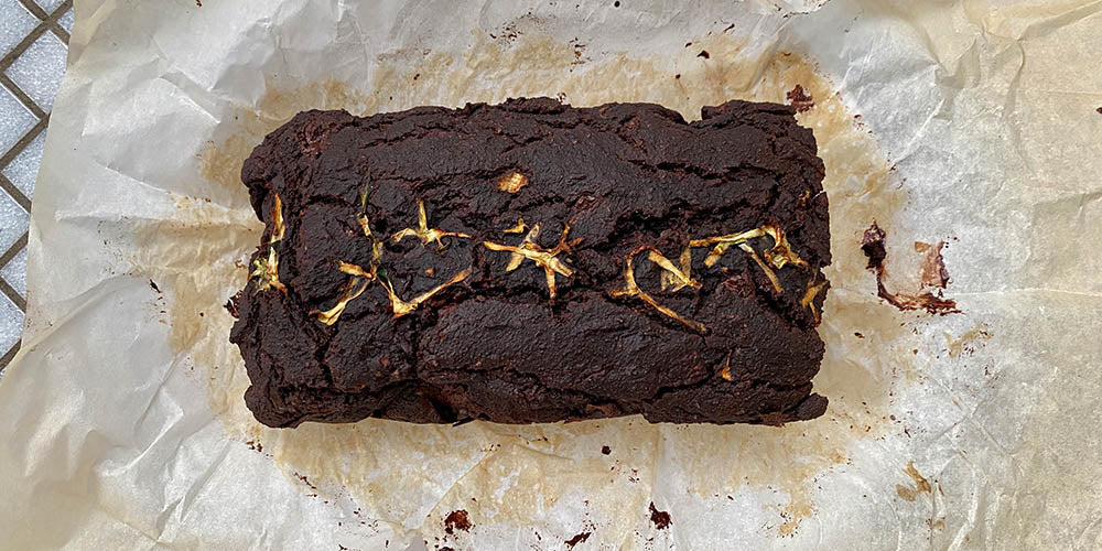 gluten-free chocolate coffee zucchini loaf cake sitting on parchment paper.